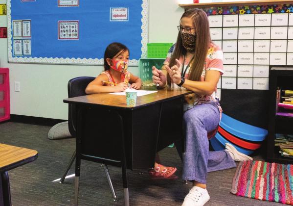 A New Normal: Aspermont ISD 2nd Grade teacher, Shasta Van Meter, gives one-on-one instruction to student, Makayla Lopez, while adhering to executive orders that require mandatory face covering.