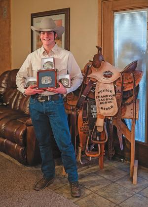 Old Glory resident, T.W. Flowers along with his collection of buckles and saddles that he has won. so far.