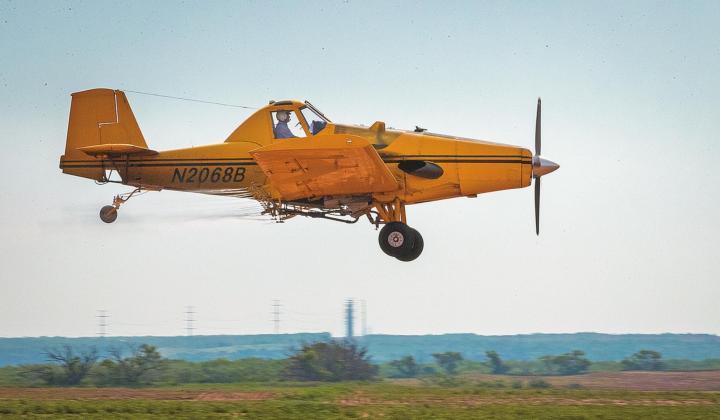 Although not the aircraft fired upon, at less than 40 feet above the ground and roughly 170 mph, Vance Lakey with Tri-County Sprayers, shows how easy of a target crop dusters can be while spraying a field north west of Rotano Monday.